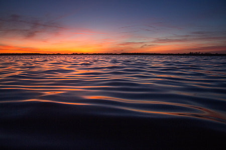 body of water under blue sky at golden hour thumbnail