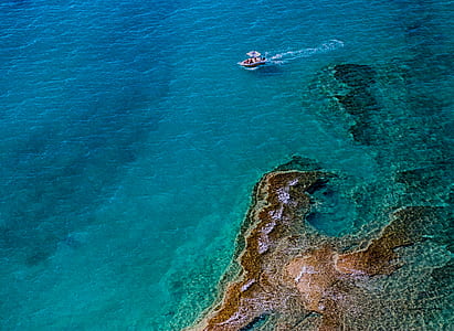 boat sailing on clear blue waters during daytime thumbnail
