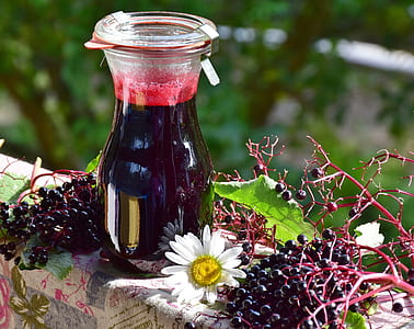selective focus photography of clear glass bottle filled with berry juice thumbnail