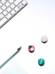 white keyboard beside pen on desk thumbnail