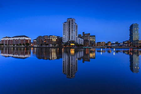 panorama photography of city buildings by the water at night thumbnail