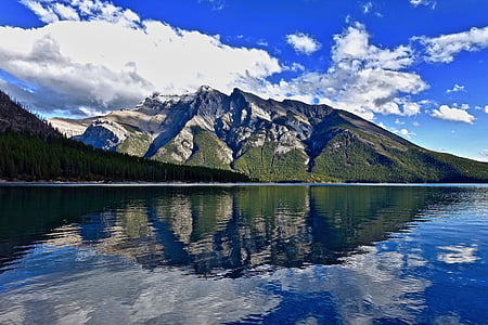 calm body of water near mountains during daytime thumbnail
