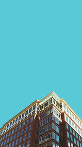 low angle photography brown high rise building under blue sky thumbnail