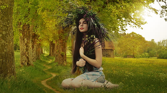 woman carrying flower while sitting on grass thumbnail