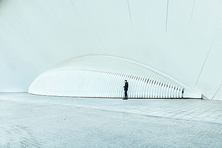 man standing near gray metal frame thumbnail