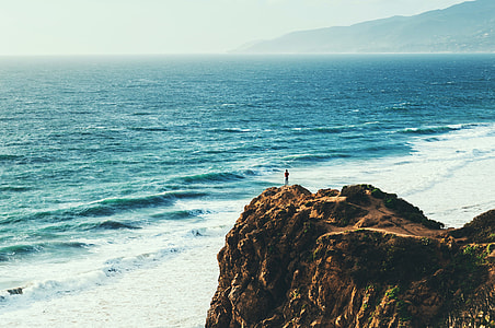 person standing on the top of mountain cliff thumbnail