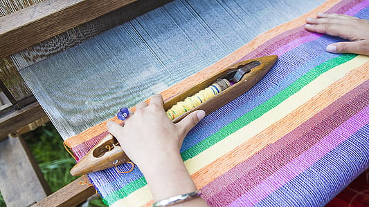 close-up of a weaver's hands on weaving machine thumbnail