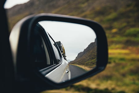 Rear view mirror of a car on a highway thumbnail