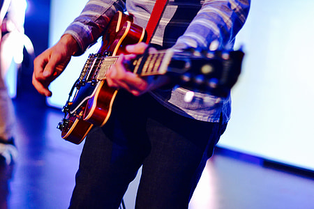 Man playing guitar on stage at a music concert thumbnail