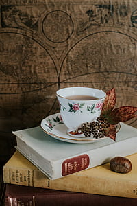 white and pink floral ceramic cup on book thumbnail