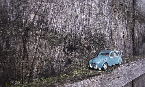 blue Volkswagen beetle die-cast model on gray wooden board thumbnail