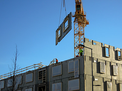 t crane pulling house window panel under blue sky thumbnail