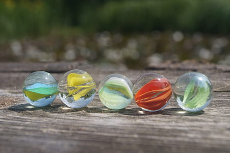 selective focus photography of five marble toys thumbnail