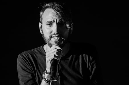 man holding microphone in dark surface thumbnail