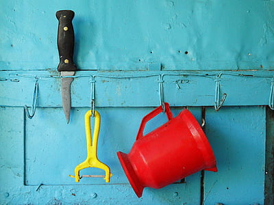 red plastic pitcher beside yellow peeler thumbnail