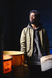 man wearing brown leather jacket standing near brown bucket thumbnail