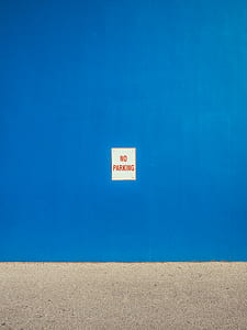 red No Parking signage plated on blue wall thumbnail
