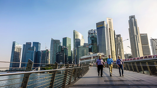 three men walking on gray concrete bridge during daytime thumbnail