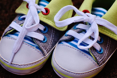 pair of baby's white-and-green lace-up shoes close-up photo thumbnail