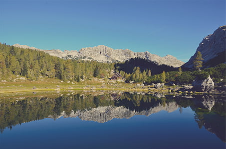 brown mountain surrounded with trees near lake thumbnail
