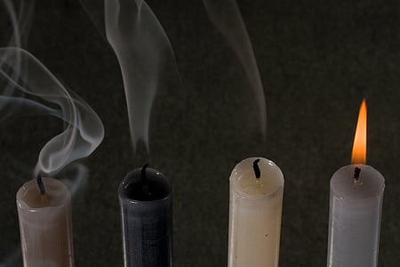 one lighted candle near turned-off candldes thumbnail
