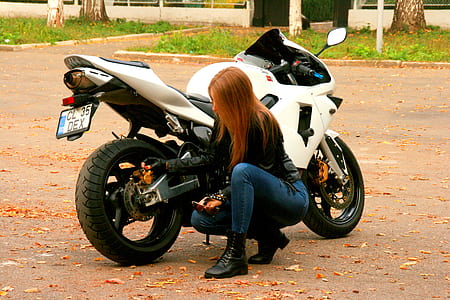 woman kneeling beside sport bike thumbnail