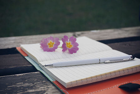white twist pen on blue-lined yellow notebook thumbnail