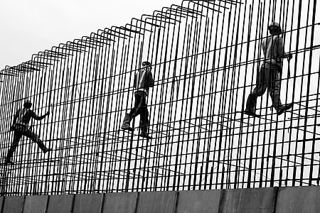 three workmen standing on gray metal rails during daytime thumbnail