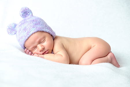 baby sleeping while wearing purple knit cap thumbnail