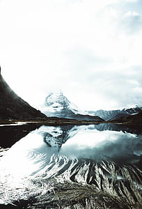 body of water beside mountain covered with snow photo thumbnail