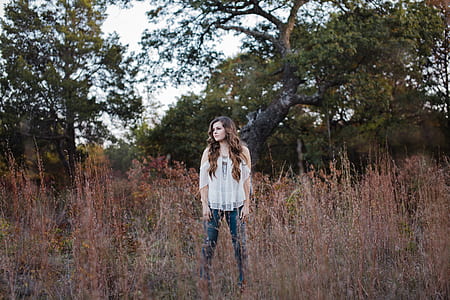 woman standing on grass field during daytime thumbnail