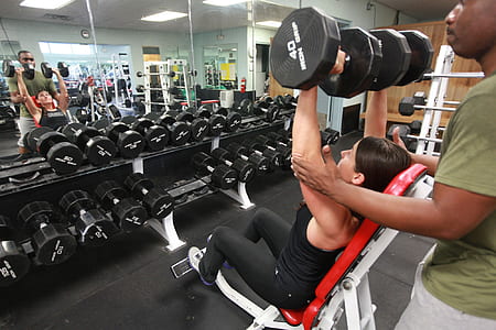 woman in black tank top holding black dumbbells thumbnail