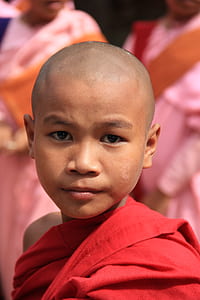 selective focus photography of boy in red monk dress thumbnail