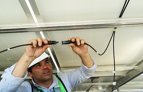 man in blue button-up long-sleeved holding wires thumbnail