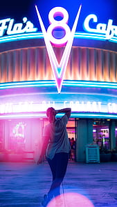 woman standing in front of 8 LED logo building signboard at nighttime thumbnail