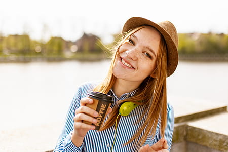 Woman Holding Cup While Taking Photo thumbnail