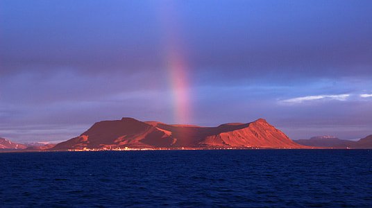 photo of mountain near body of water under white clouds at noontime thumbnail