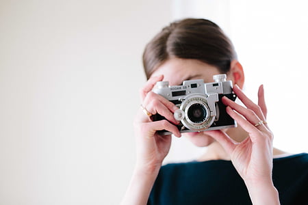 woman taking photo using film camera thumbnail