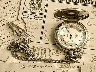 silver-colored pocket watch on white printed papers thumbnail
