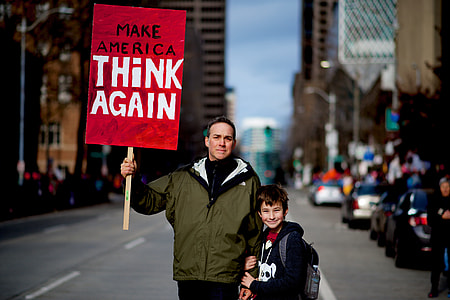 man holding signage on street thumbnail