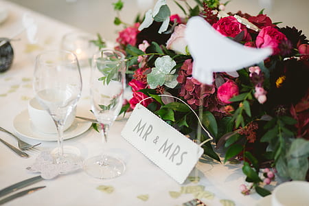 two clear champagne glasses beside bouquet of flowers thumbnail