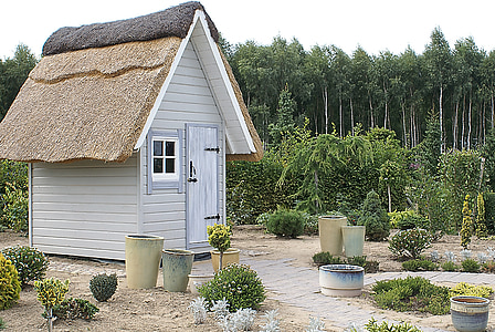 white shed beside green trees during daytime thumbnail