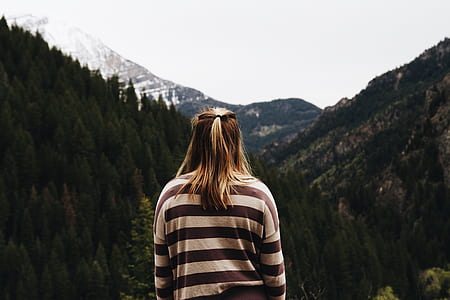 woman wearing white and black striped long-sleeved shirt facing mountain canyon thumbnail