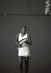 gray scale photo of woman holding tennis racket thumbnail