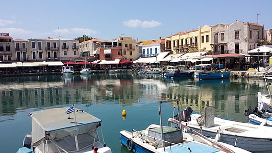 assorted-color yacht near sea beside buildings at daytime thumbnail