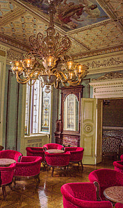gold uplight chandelier over pink chairs thumbnail