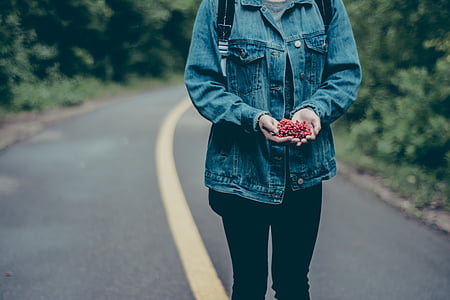 person standing on road holding flower thumbnail