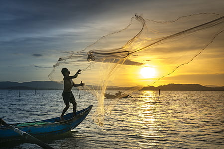 man on boat throwing fish net thumbnail