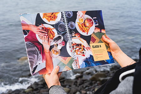 person reading cookbook in front of body of water thumbnail