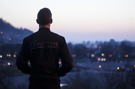 man in black League jacket standing thumbnail